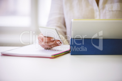 Midsection of executive with wireless technologies at desk in of
