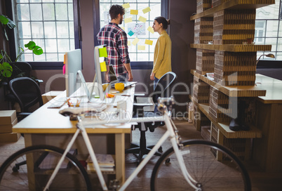 Bicycle by desk while coworkers discussing in background