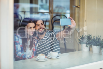 Couple taking selfie at cafe