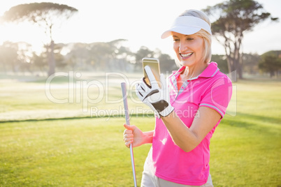 Woman golfer looking her mobile phone