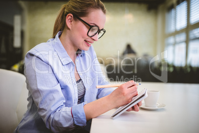 Businesswoman writing on document