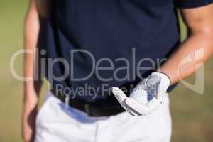 Midsection of man holding golf ball