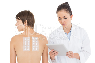 Doctor by patient holding digital tablet