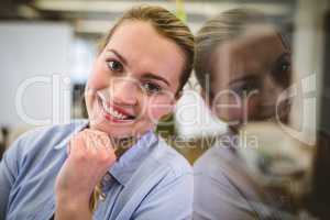 Happy businesswoman leaning on glass