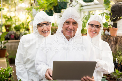 Happy coworkers in clean suit with laptop