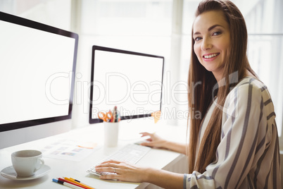 Portrait of businesswoman working on computer in office