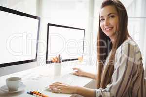 Portrait of businesswoman working on computer in office