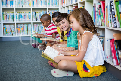 Students reading books while sitting at school library