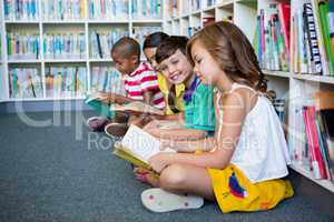 Students reading books while sitting at school library