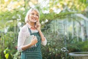 Female gardener smiling while talking on cellphone