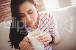 Woman holding coffee cup on couch
