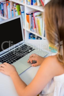 Girl using laptop in school library
