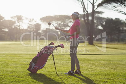 Side view of woman carrying golf club