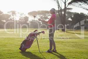 Side view of woman carrying golf club