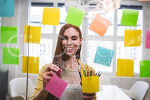 Businesswoman writing on sticky notes