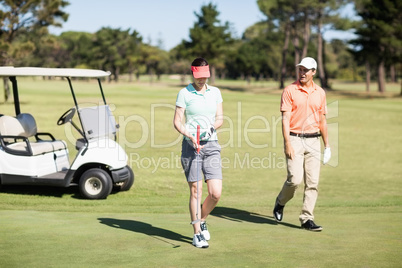 Golfer couple walking on field