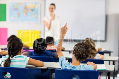 Teacher pointing boy with raised hand