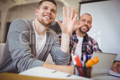 Young businessmen gesturing at desk in creative office