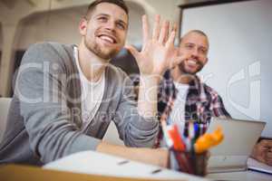 Young businessmen gesturing at desk in creative office
