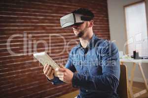 Man wearing virtual glass while holding digital tablet