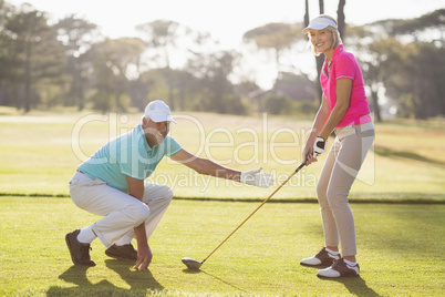 Side view of mature couple playing golf