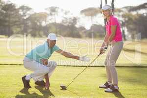 Side view of mature couple playing golf