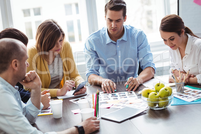 Editors with documents working in meeting room
