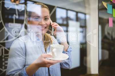 Portrait of businesswoman talking on phone during coffee break