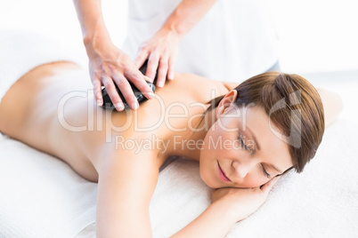 Beautiful woman enjoying hot stone massage