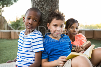 Portrait of children reading books at park