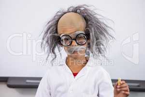 Boy dressed as scientist holding paper in classroom