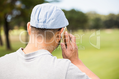 Rear view of golfer calling