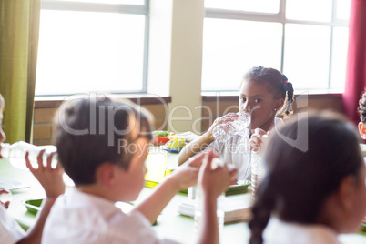 Schoolgirl drinking water from bottle