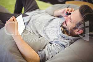 Businessman using digital tablet and mobile phone while relaxing