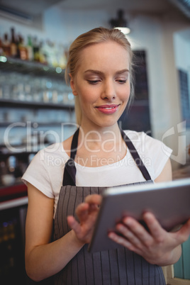 Happy owner using digital tablet at coffee shop