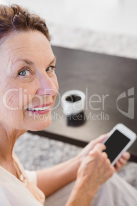 Portrait of cheerful mature woman holding smartphone