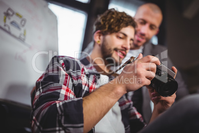 Male coworkers looking in camera at creative office