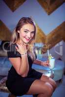 Portrait of woman enjoying cocktail in nightclub