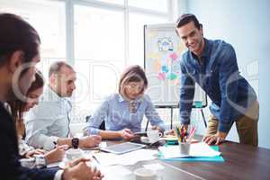 Smiling businessman with coworkers in meeting room