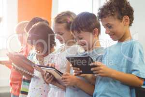 Smiling children using digital tablets