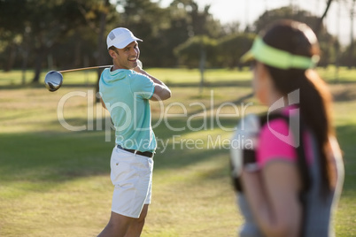 Smiling golfer man looking at woman