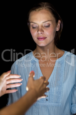 Cropped image of hypnotist hypnotizing woman