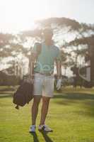 Full length of golf player carrying bag