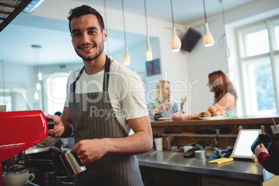 Portrait of happy barista at coffee shop