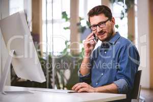 Portrait of confident executive talking on cellphone at office