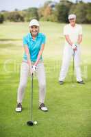 Portrait of smiling mature couple playing golf