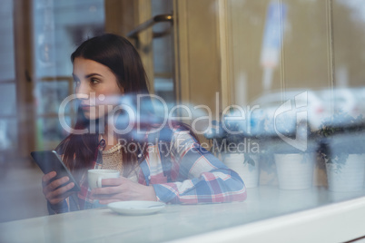Beautiful woman using mobile phone at cafe