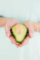 Woman holding avocado fruit