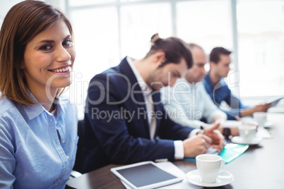 Smiling businesswoman with coworkers in meeting room