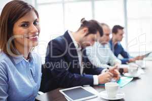 Smiling businesswoman with coworkers in meeting room